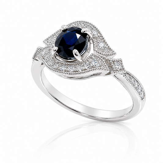 14K white gold vintage-inspired ring featuring a 1.03 carat oval blue sapphire and 0.26 CTTW of diamond accents.