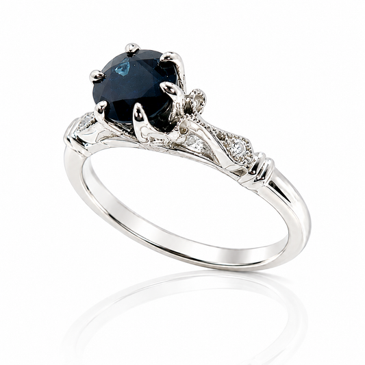 14K white gold vintage-inspired ring featuring a 0.71 carat round blue sapphire with diamond, milgrain, and scrollwork accents.