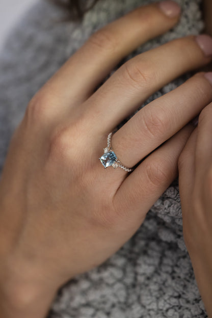 Aquamarine & Diamond Ring on lady's hand wearing grey sweater 