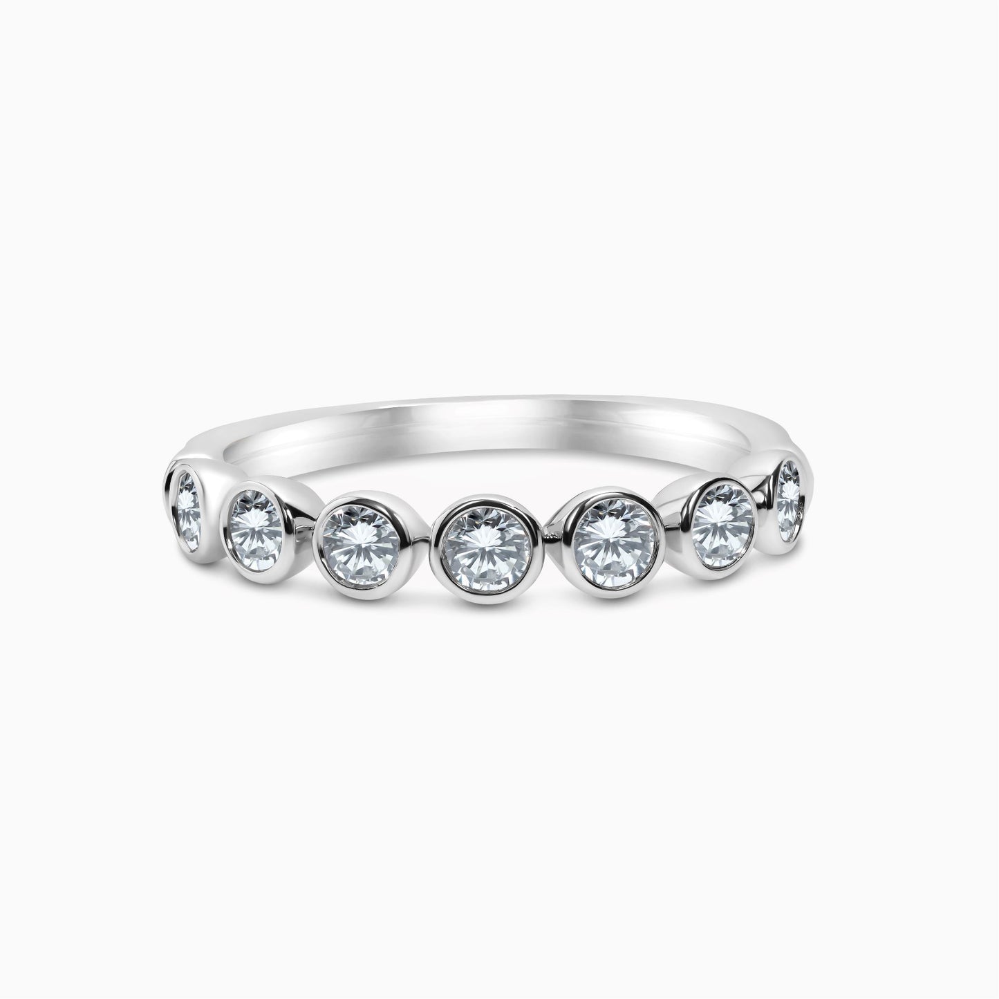 A 14k white gold bezel set diamond band with 7 round-cut diamonds.