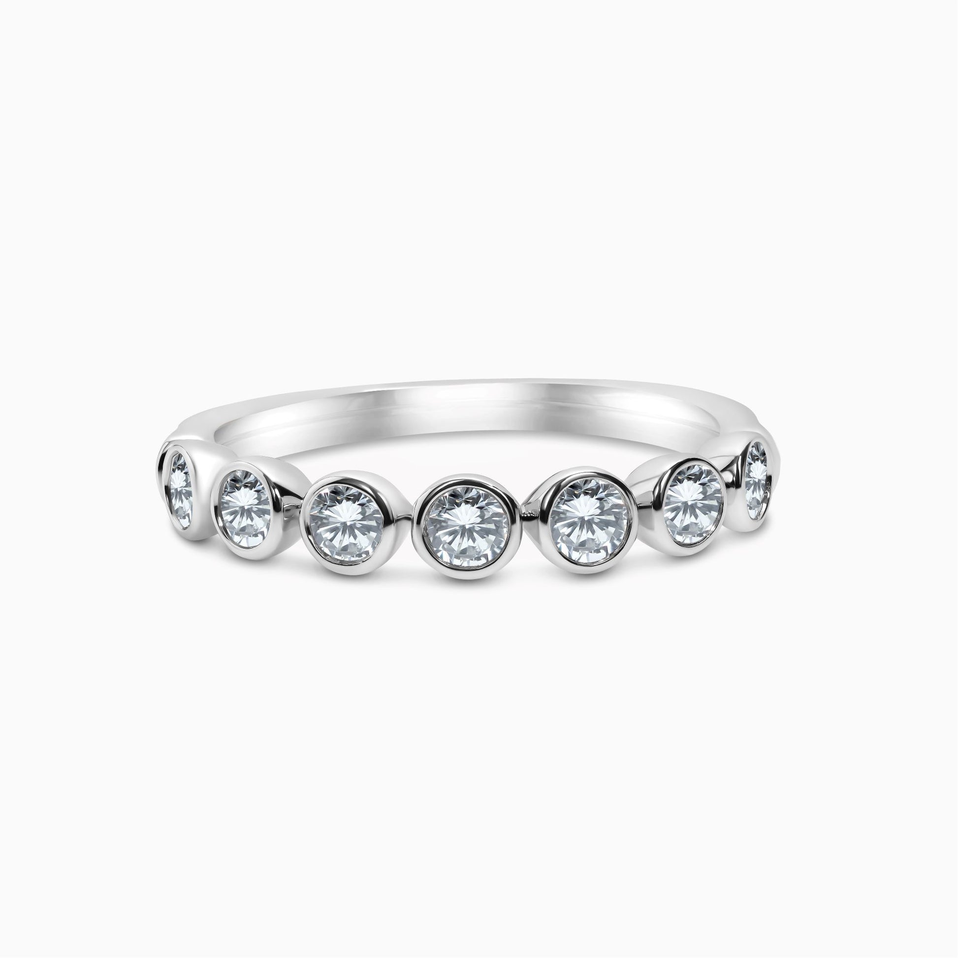 A 14k white gold bezel set diamond band with 7 round-cut diamonds.