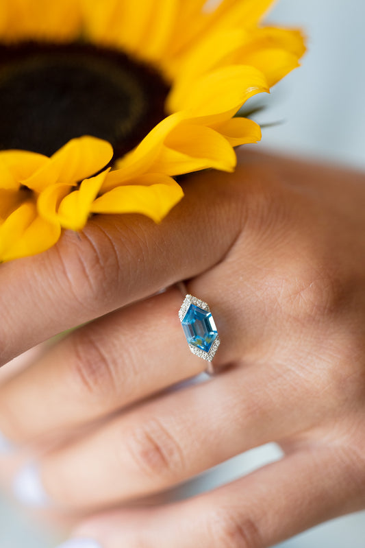 Fancy Cut Blue Topaz Ring on hand holding sunflower