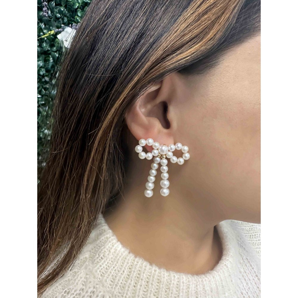 Pearl Bow Earrings on ear