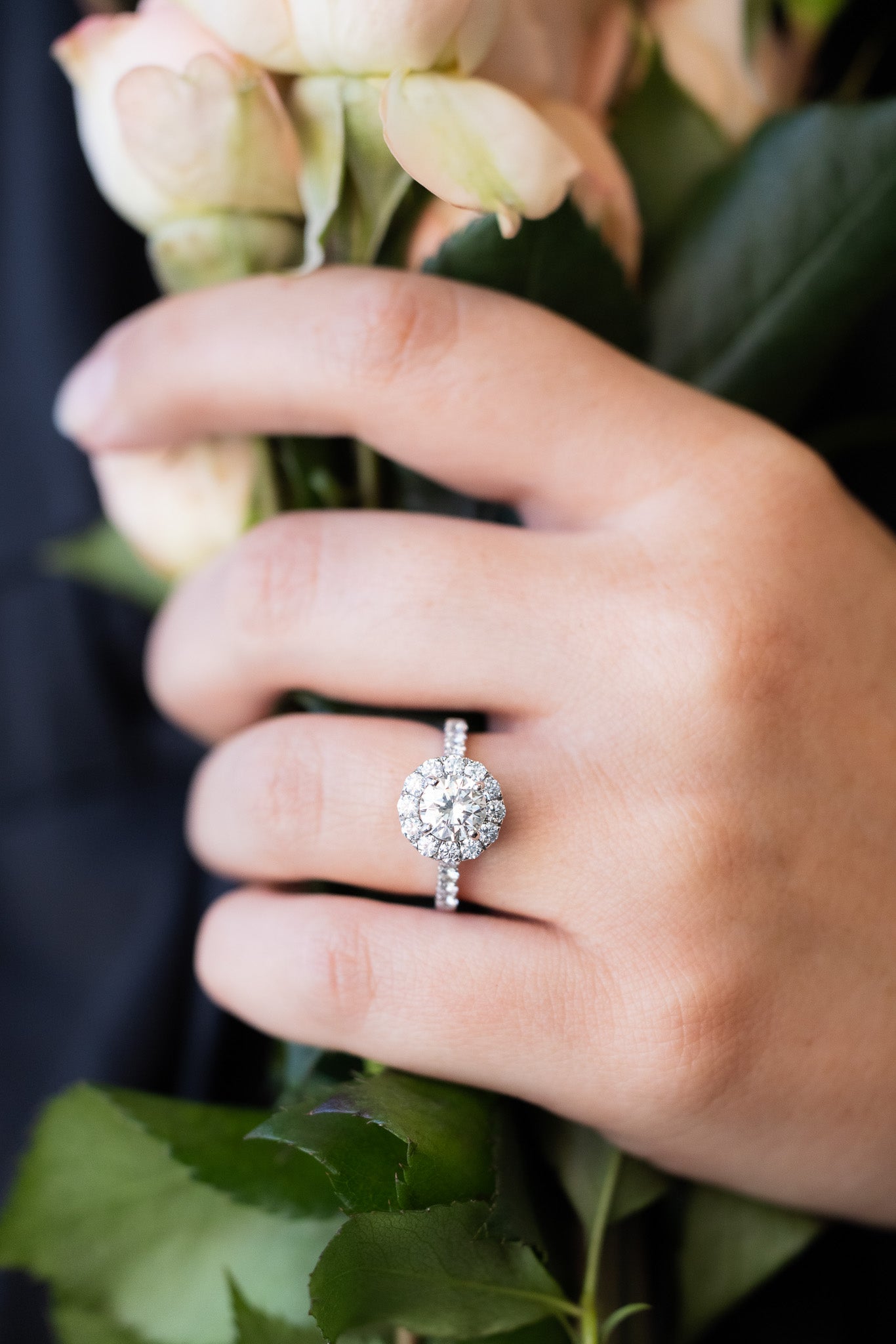 Diamond Halo Ring on hand holding flowers