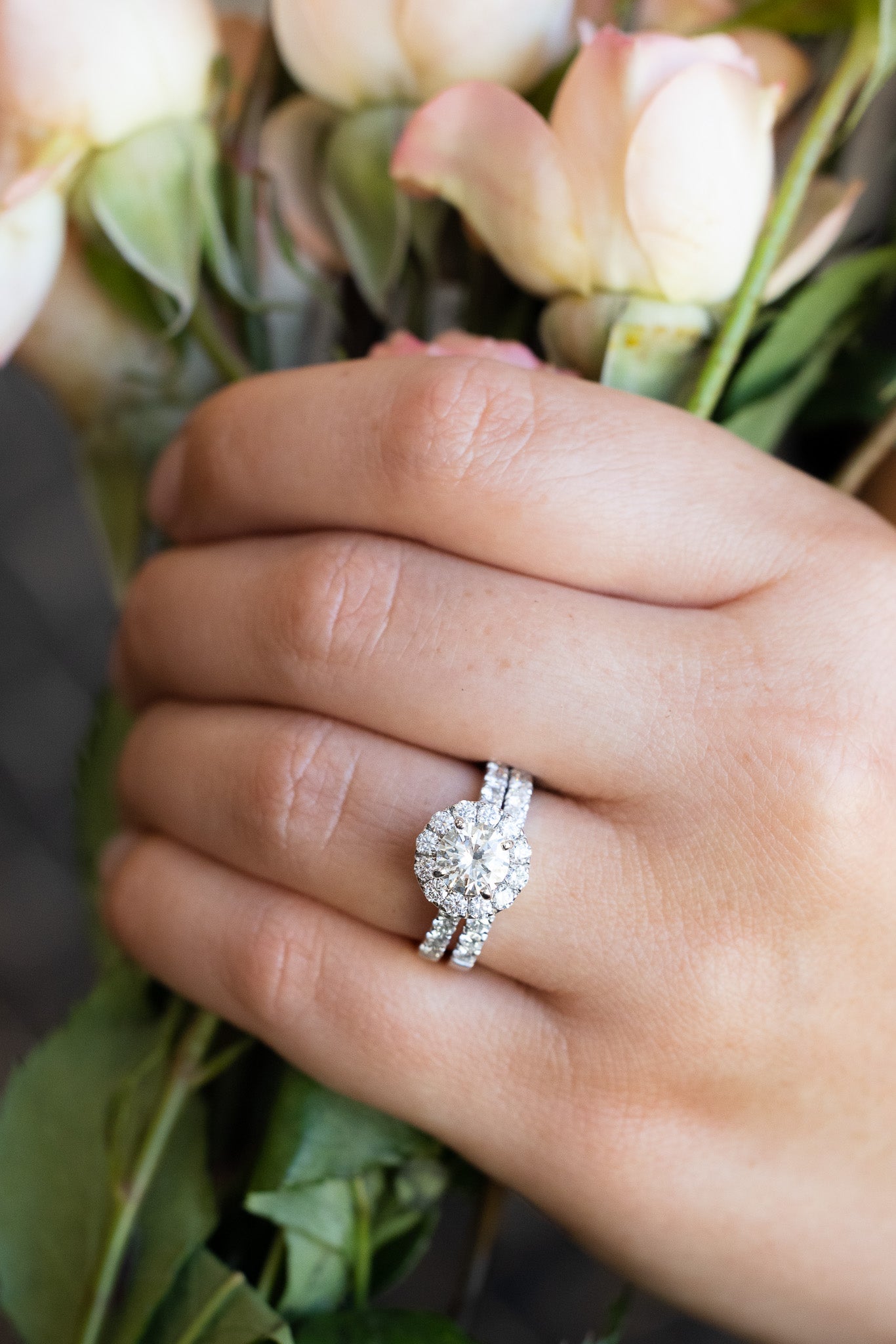14K White Gold Wedding Set
1.12 Carat Round Brilliant Cut Diamond - VS1 / L
1.55 Carat t.w. Accent Diamonds
On hand holding roses