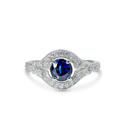 A 14k white gold ring with a blue sapphire in the center and accent diamonds set in a white gold band.