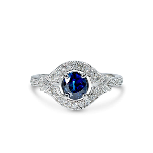 A 14k white gold ring with a blue sapphire in the center and accent diamonds set in a white gold band.